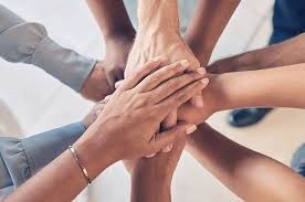 Hands stacked in a circle, showing unity and teamwork.